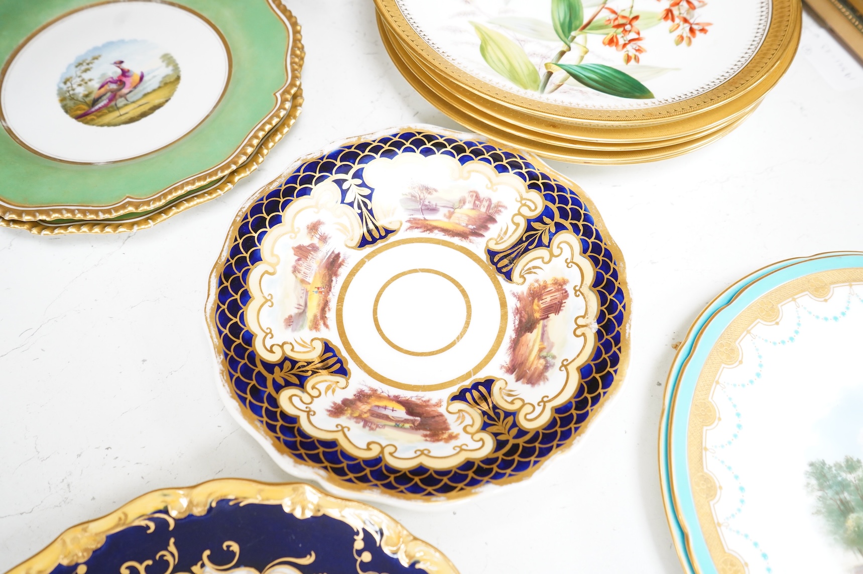 A collection of 19th century English dessert wares to include a pair of Flight, Barr and Barr ‘fantastic birds’ green ground dessert plates, various Ridgway dessert plates, five Minton botanical plates with tooled gilt b